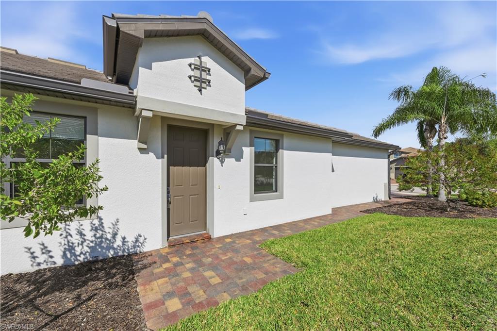 7733 Jacaranda Lane Naples, FL 34114 - Photo 4 of 38 a view of a white house with a large window and potted plants