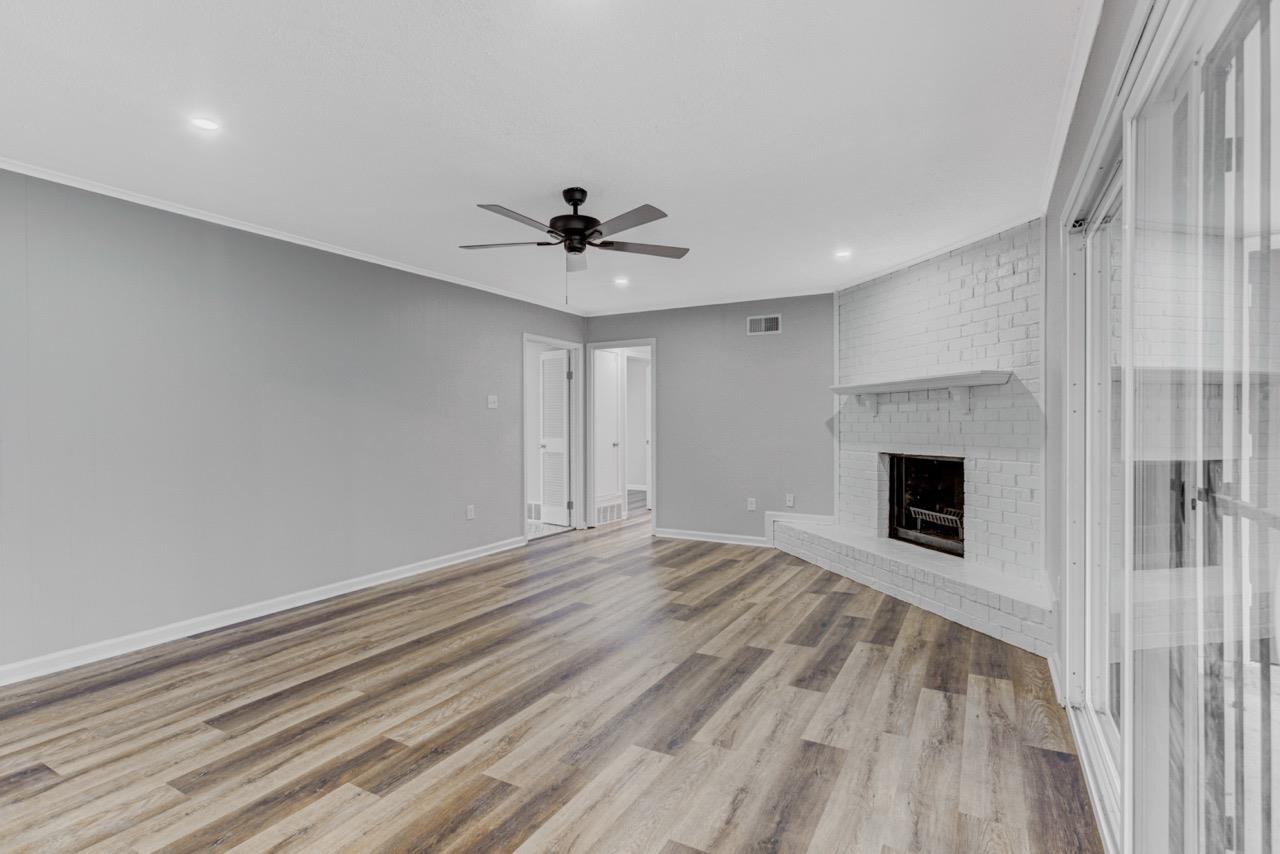 3187 Belle Tower Road Memphis, TN 38115 - Photo 13 of 24 Unfurnished living room with a fireplace, recessed lighting, light wood-style floors, and a ceiling fan