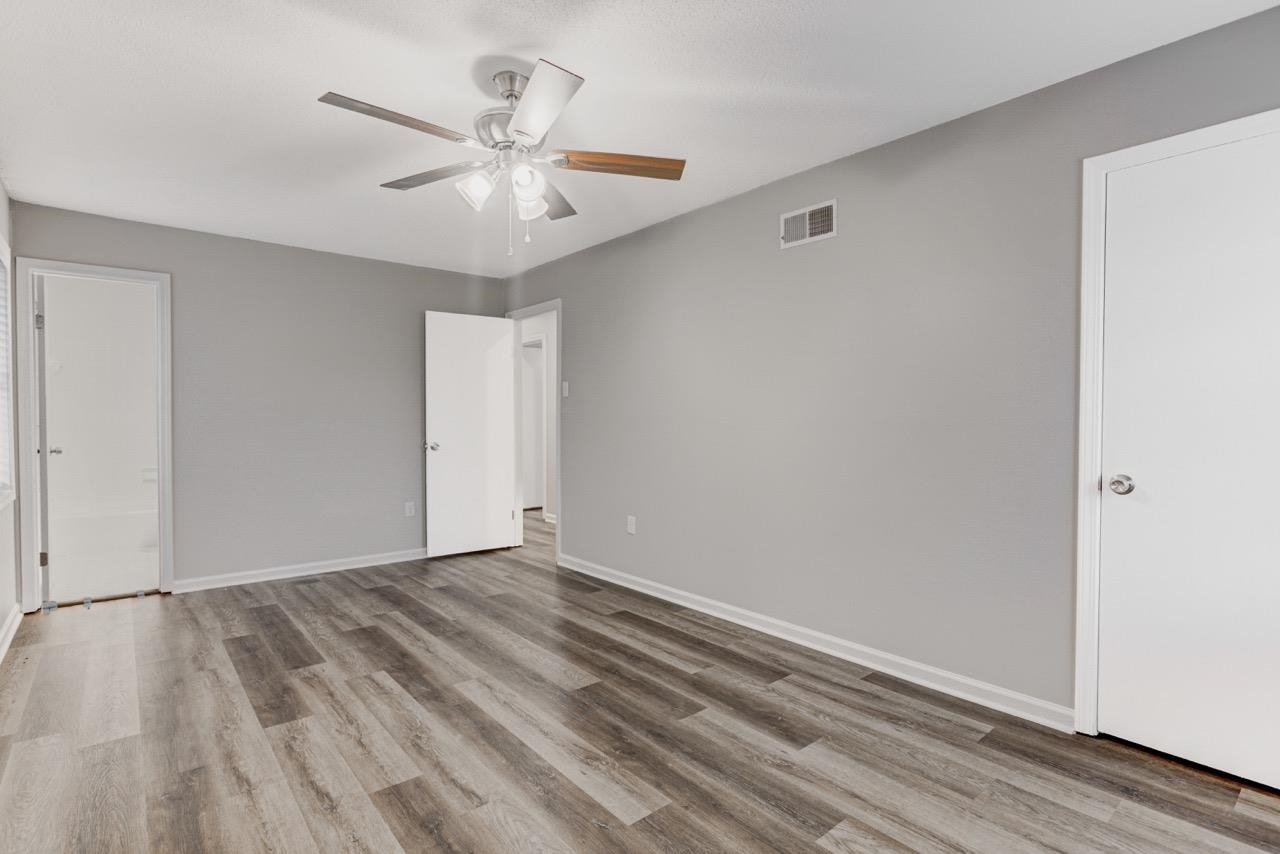 3187 Belle Tower Road Memphis, TN 38115 - Photo 20 of 24 Unfurnished bedroom featuring a ceiling fan, light wood-type flooring, and connected bathroom