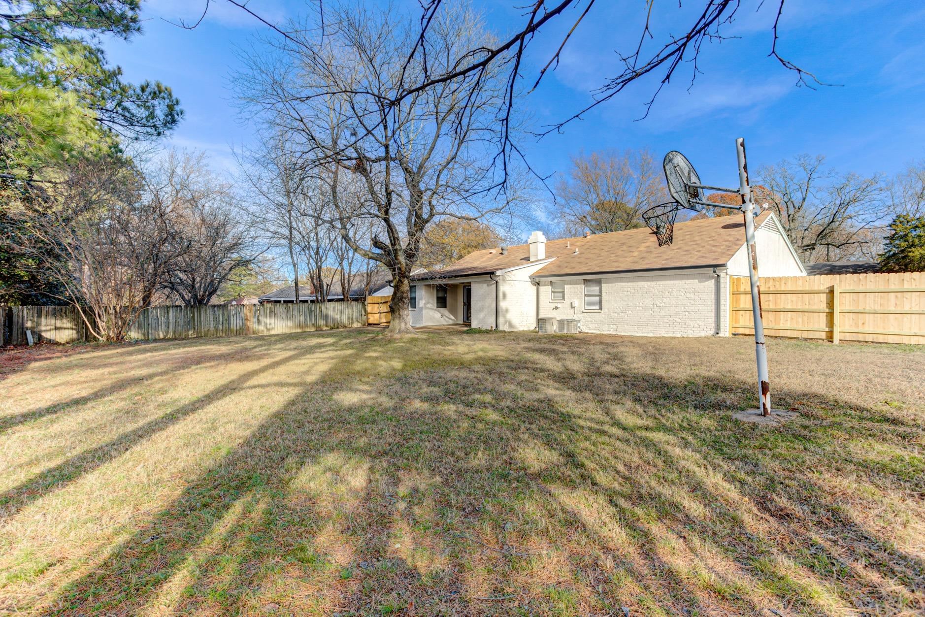 3187 Belle Tower Road Memphis, TN 38115 - Photo 24 of 24 Rear view of house featuring a fenced backyard, a chimney, and brick siding