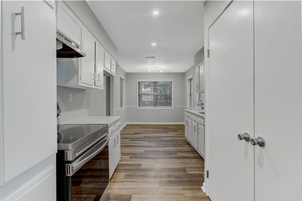 3187 Belle Tower Road Memphis, TN 38115 - Photo 10 of 24 Kitchen featuring stainless steel range with electric stovetop, white cabinetry, light countertops, under cabinet range hood, and recessed lighting