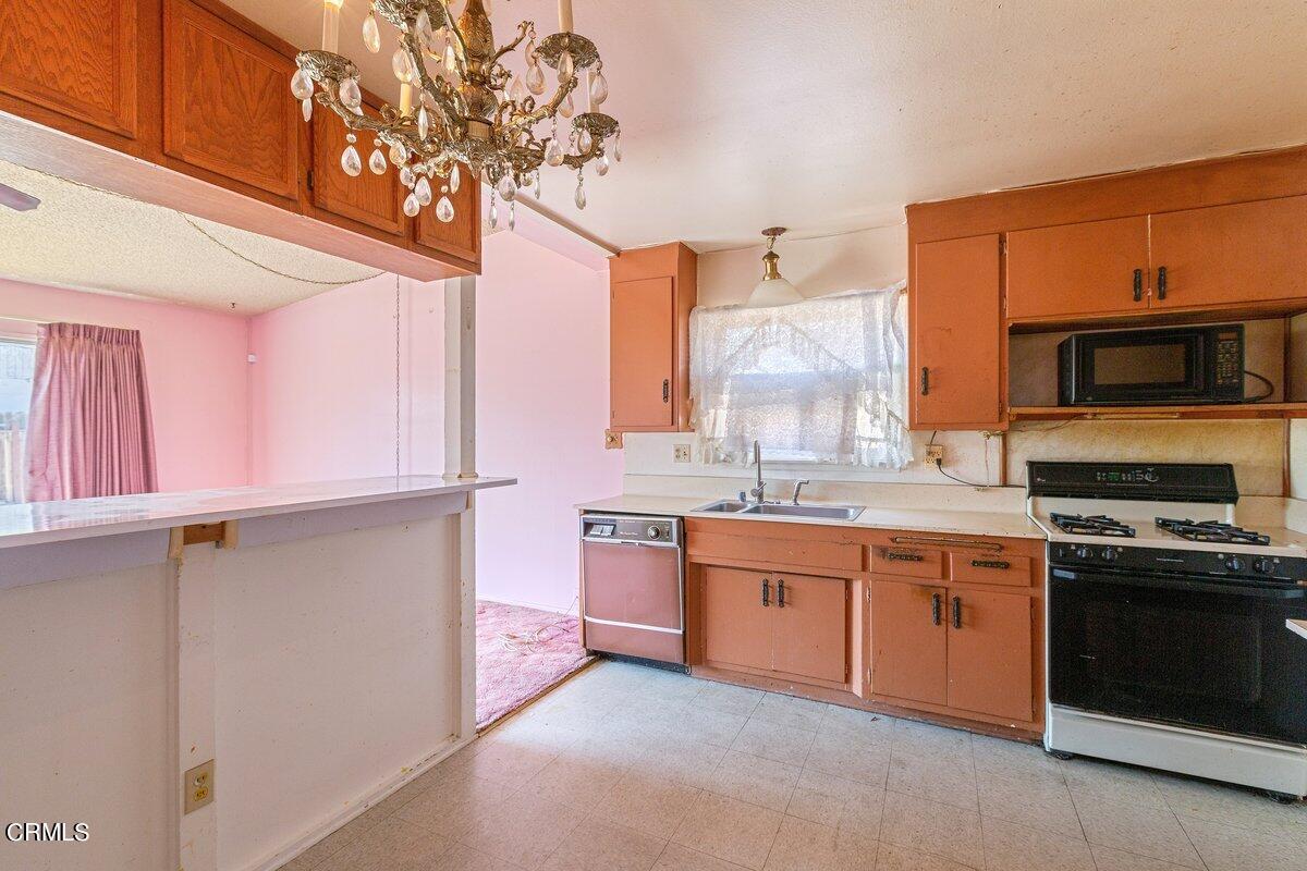 1931 Ukiah Street Oxnard, CA 93035 - Photo 8 of 21 a kitchen with stainless steel appliances granite countertop a stove a sink and a microwave