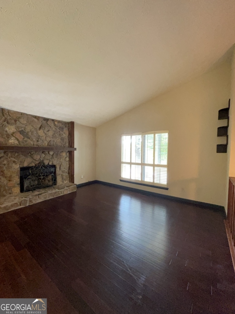 1265 Herrington Road Lawrenceville, GA 30044 - Photo 4 of 52 an empty room with wooden floor and fireplace