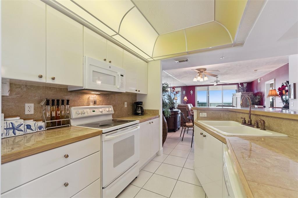 4621 South Atlantic Avenue, Unit 7506 Ponce Inlet, FL 32127 - Photo 12 of 46 a kitchen with granite countertop a sink a counter top space appliances and cabinets
