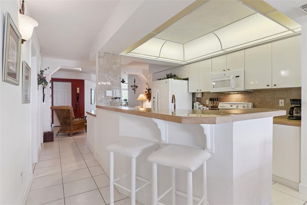 4621 South Atlantic Avenue, Unit 7506 Ponce Inlet, FL 32127 - Photo 14 of 46 a kitchen with cabinets and chairs