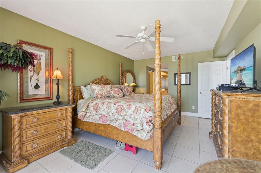 4621 South Atlantic Avenue, Unit 7506 Ponce Inlet, FL 32127 - Photo 26 of 46 a bedroom with a bed a dresser and potted plants