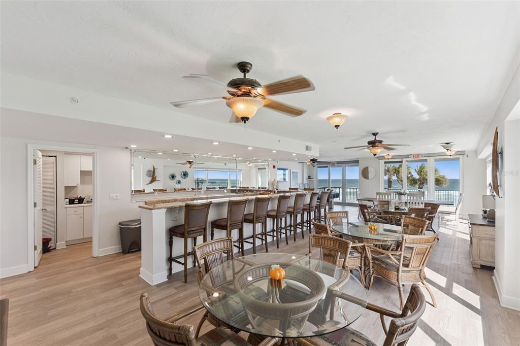 4621 South Atlantic Avenue, Unit 7506 Ponce Inlet, FL 32127 - Photo 36 of 46 a dining room with wooden floor a chandelier a wooden table and chairs