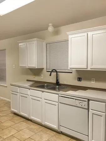 a kitchen with stainless steel appliances granite countertop white cabinets sink and dishwasher