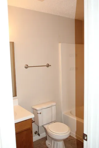 a white toilet sitting next to a shower