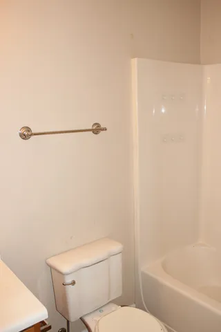 a white toilet sitting next to a bath tub