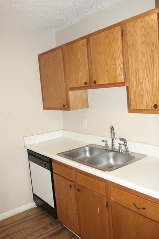 a kitchen with a sink cabinets and wooden floor