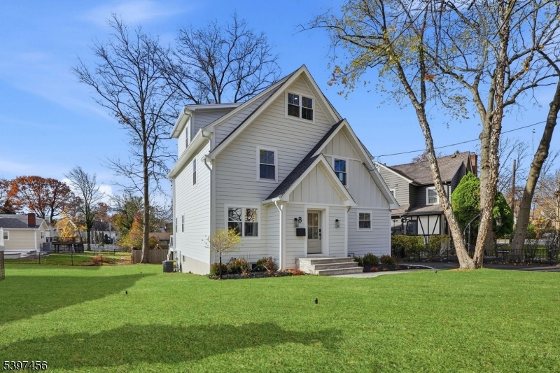 a front view of a house with a yard and trees