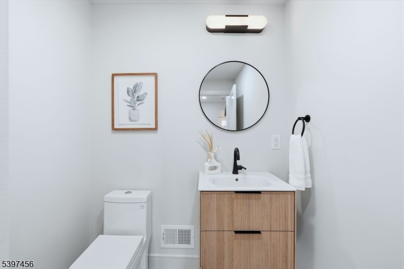 8 Mountainview Road Millburn, NJ 07041 - Photo 17 of 46 a bathroom with a toilet a sink and mirror