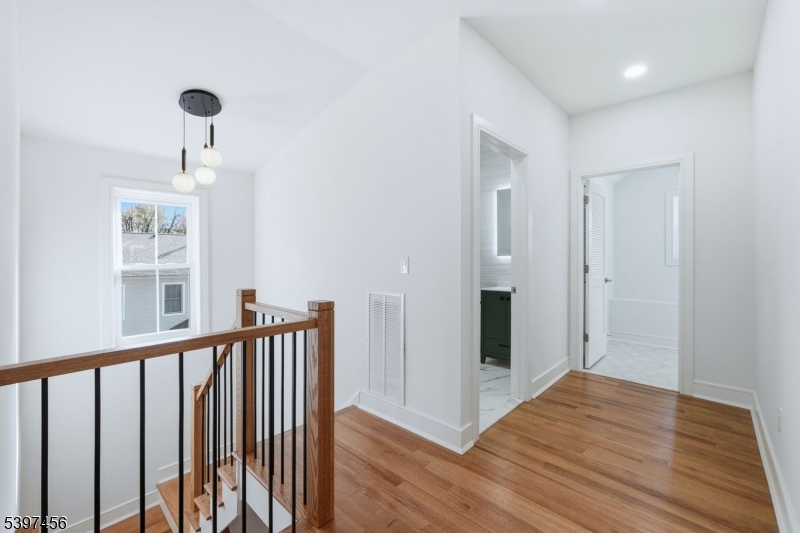 8 Mountainview Road Millburn, NJ 07041 - Photo 30 of 46 a view of a hallway with wooden floor and a chandelier