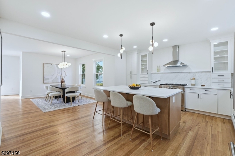8 Mountainview Road Millburn, NJ 07041 - Photo 5 of 46 a kitchen with stainless steel appliances granite countertop a stove a sink dishwasher a dining table and chairs with wooden floor