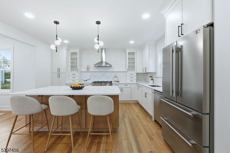 8 Mountainview Road Millburn, NJ 07041 - Photo 6 of 46 a kitchen with stainless steel appliances granite countertop a refrigerator a sink dishwasher a stove a dining table and chairs with wooden floor