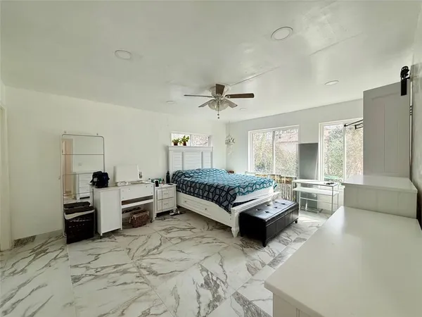 a bedroom with furniture and a large window