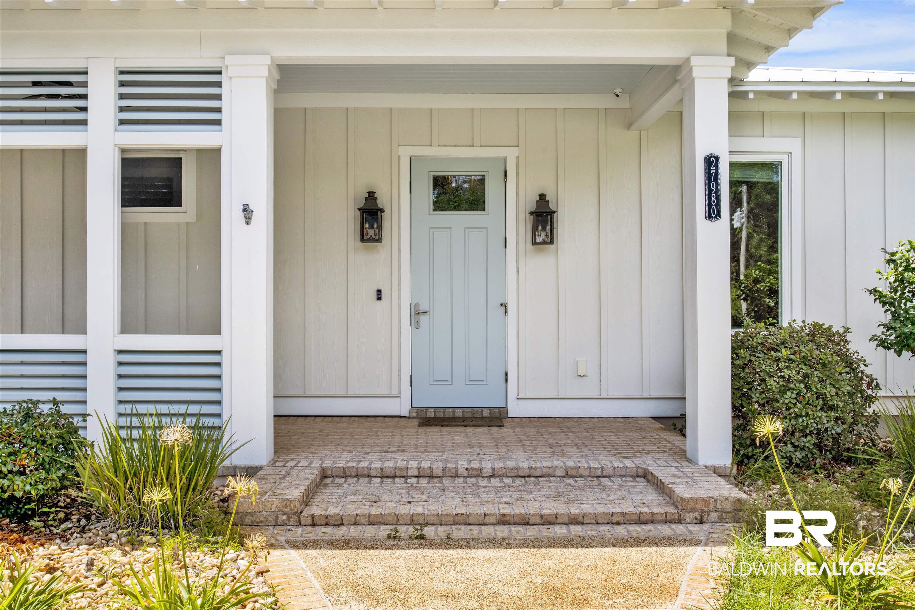 27980 Canal Road Orange Beach, AL 36561 - Photo 14 of 46 View of exterior entry featuring board and batten siding, a porch, and a metal roof