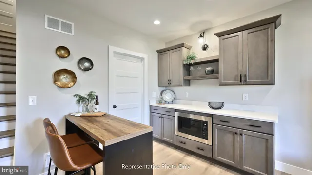 a kitchen with stainless steel appliances granite countertop a stove top oven a sink a dining table and chairs