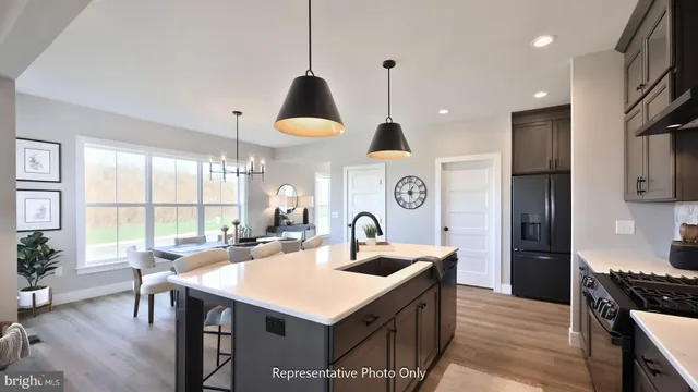 a kitchen with kitchen island a sink a stove and a refrigerator