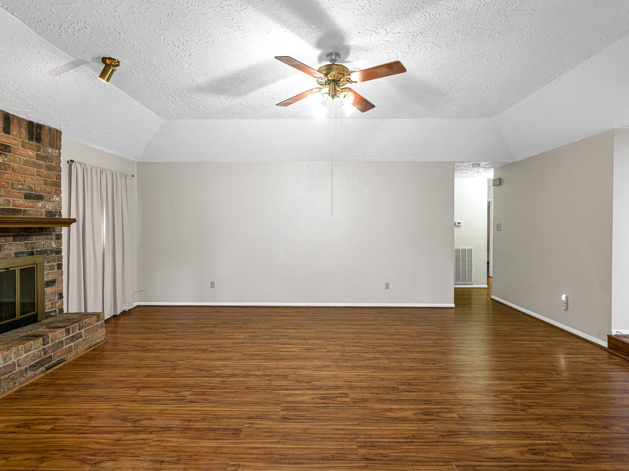 22906 Squirrel Tree Street Spring, TX 77389 - Photo 14 of 41 a view of an empty room with a fireplace and a ceiling fan