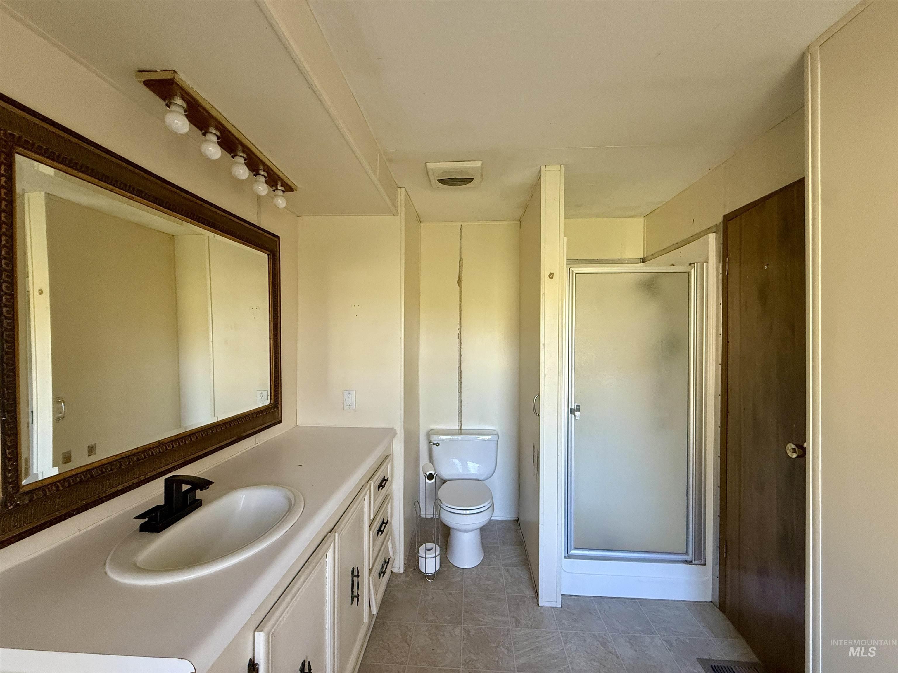 191 Battle Ridge Road Kooskia, ID 83539 - Photo 19 of 35 Full bath featuring vanity, a shower stall, and light tile patterned flooring