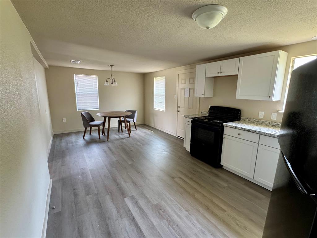 211 Sperry Lane Red Oak, TX 75154 - Photo 6 of 16 a kitchen with a table chairs wooden floors and a view of living room