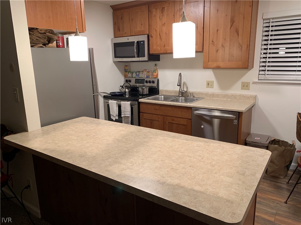 609 Village Boulevard Incline Village, NV 89451 - Photo 19 of 21 a kitchen with stainless steel appliances kitchen island a sink dishwasher a stove a refrigerator a sink with wooden cabinets and wooden floor