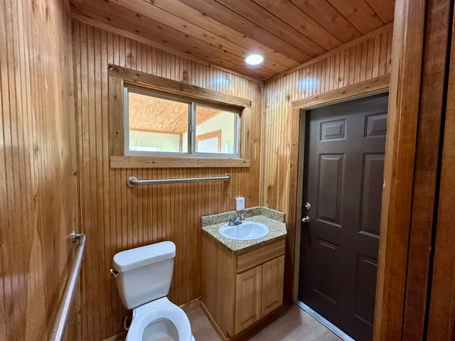 a bathroom with a granite countertop toilet sink and mirror