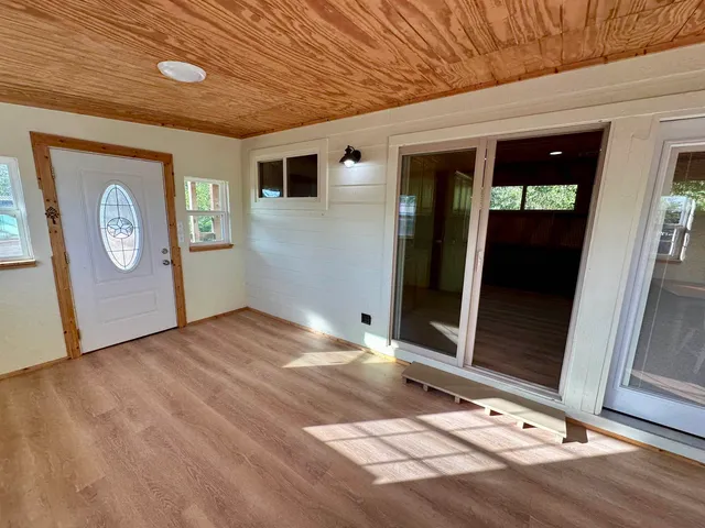 a view of a hallway with wooden floor and a ceiling fan