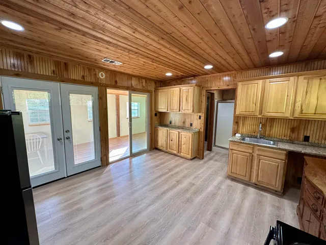 a large kitchen with stainless steel appliances granite countertop a large stove a refrigerator a sink and dishwasher with wooden floor