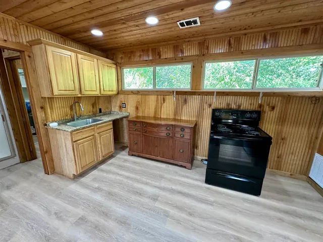 a kitchen with stainless steel appliances granite countertop a stove a sink and a refrigerator