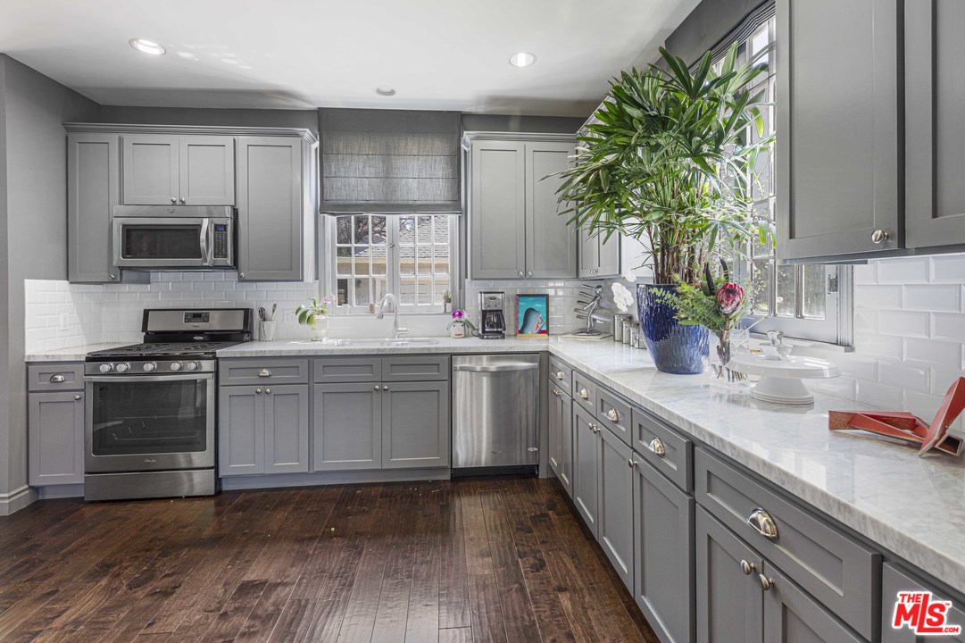 1908 Buckingham Road Los Angeles, CA 90016 - Photo 16 of 39 a kitchen with sink a microwave and cabinets