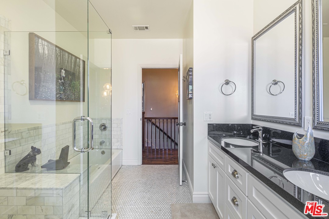 1908 Buckingham Road Los Angeles, CA 90016 - Photo 31 of 39 a bathroom with a granite countertop sink and a mirror