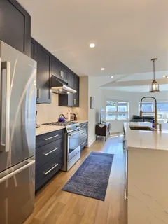 a kitchen with granite countertop white cabinets and white appliances