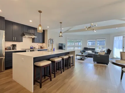 a kitchen with stainless steel appliances granite countertop a sink a stove and a refrigerator