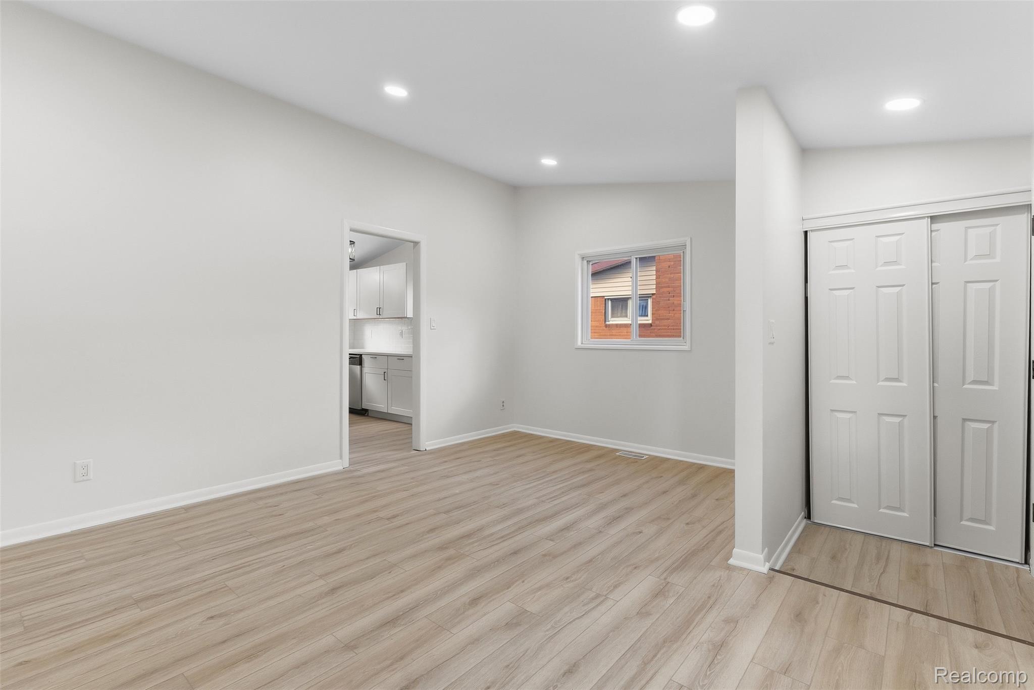9101 Merriman Road Livonia, MI 48150 - Photo 8 of 41 Recessed ceiling lighting, light wood-finish flooring, white painted walls, and a sliding door closet