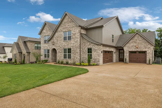 a view of an empty room with wooden floor fireplace and chandelier