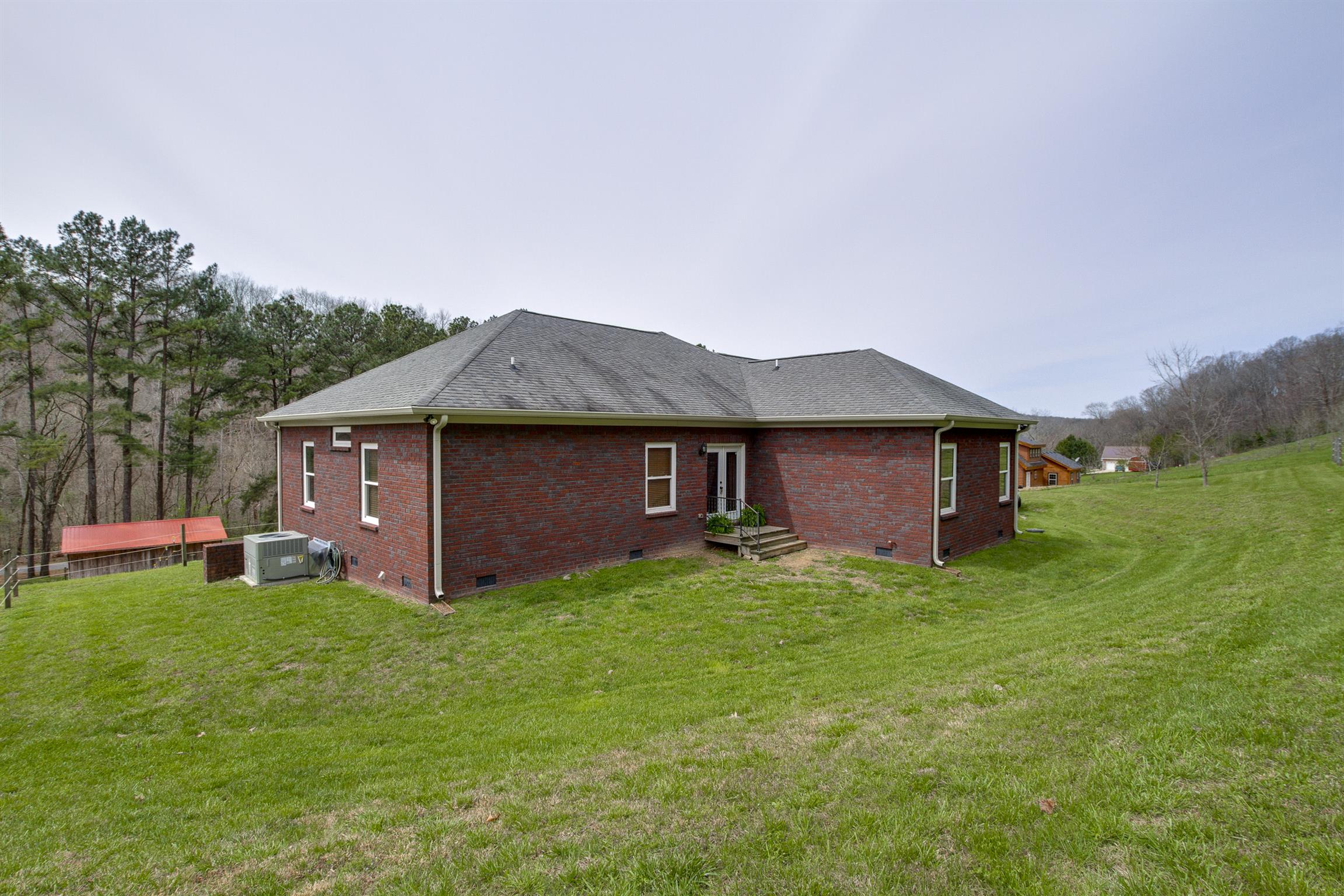 4194 Skelley Road Santa Fe, TN 38482 - Photo 25 of 30 a house that is sitting in the grass with large trees and plants
