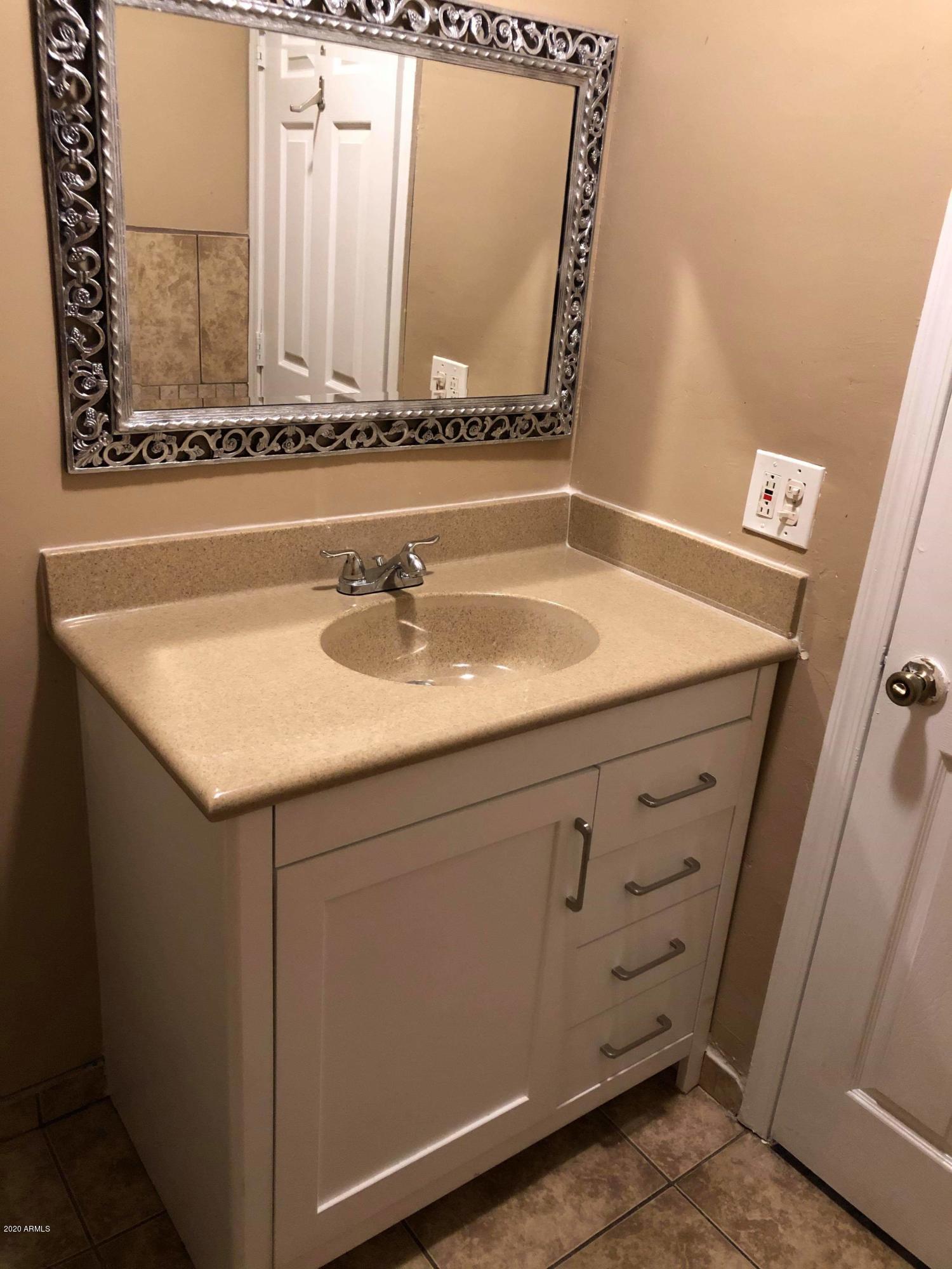 3601 West Coronado Road Phoenix, AZ 85009 - Photo 7 of 8 a bathroom with a sink and a mirror