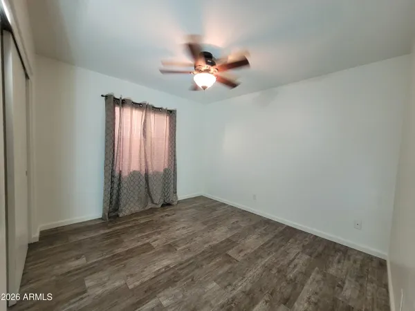 an empty room with closet and windows