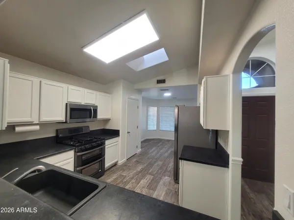 a kitchen with stainless steel appliances kitchen island granite countertop a stove a sink and a microwave