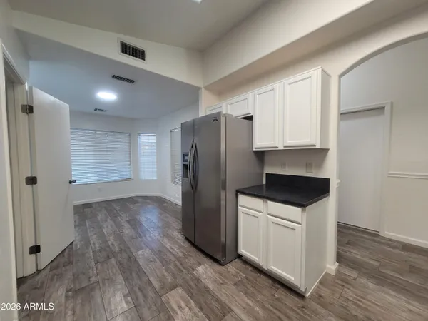 a kitchen with granite countertop a refrigerator and a stove top oven