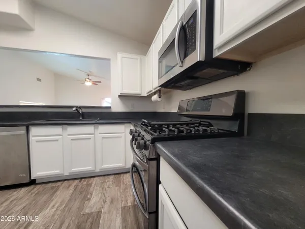 a kitchen with granite countertop a stove and a microwave