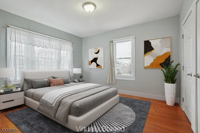 a bedroom with a large bed a flat screen tv and windows