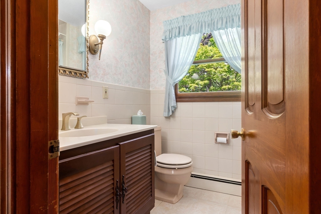 24 Flume Road Gloucester, MA 01930 - Photo 19 of 40 a bathroom with a granite countertop sink toilet and a window
