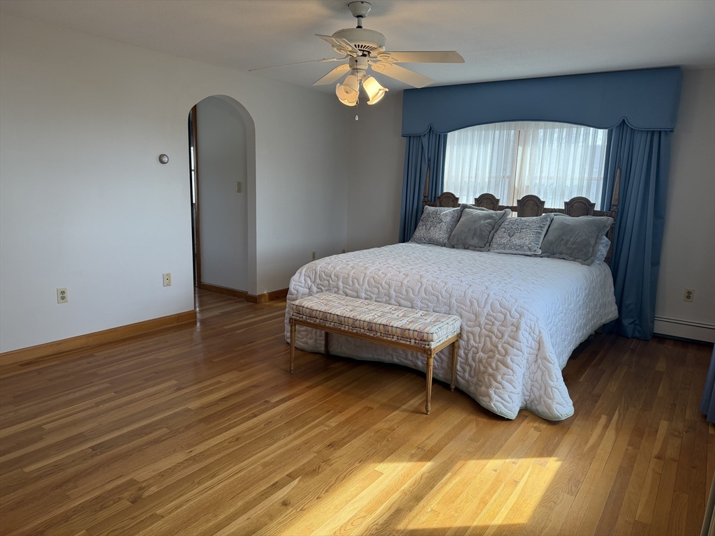 24 Flume Road Gloucester, MA 01930 - Photo 21 of 40 a spacious bedroom with a bed and a chandelier