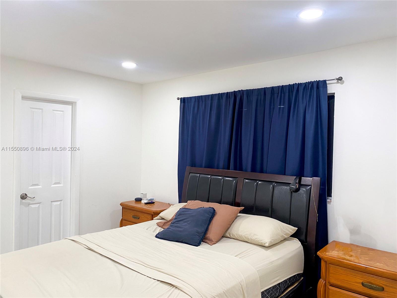 11032 Southwest 5th Street Sweetwater, FL 33174 - Photo 12 of 24 a bedroom with a bed and wooden closet
