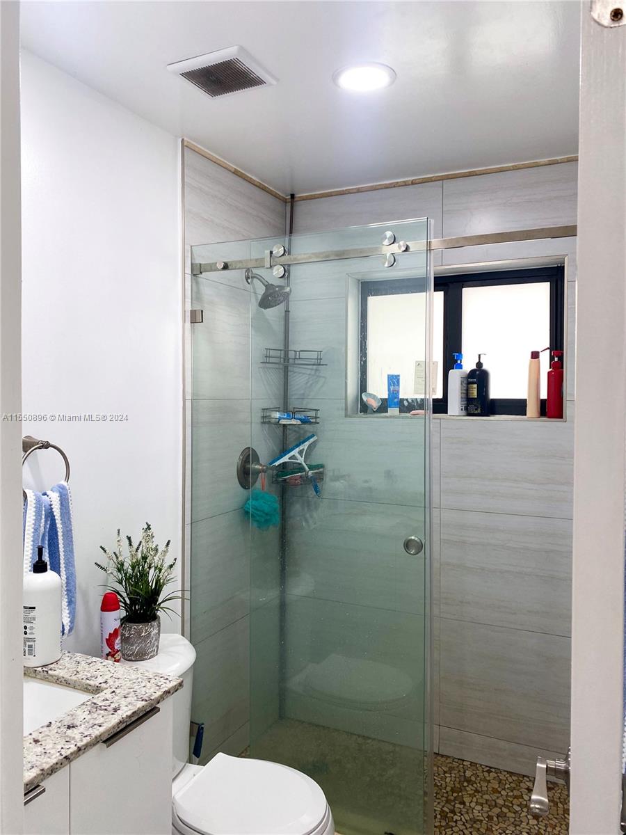 11032 Southwest 5th Street Sweetwater, FL 33174 - Photo 16 of 24 a bathroom with a granite countertop sink toilet and shower