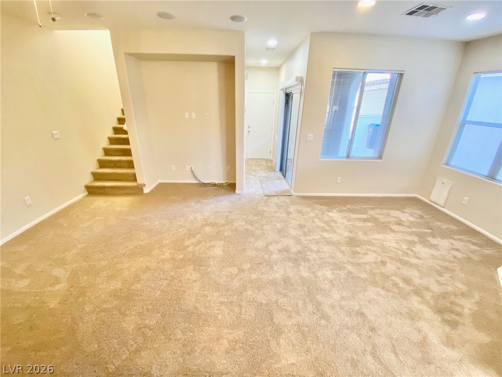 8569 Rhamus Court Las Vegas, NV 89149 - Photo 2 of 35 A spacious living area features soft carpeting and generous wall space for versatile arrangements.